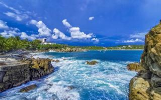 schöne surferwellen felsen klippen am strand puerto escondido mexiko. foto