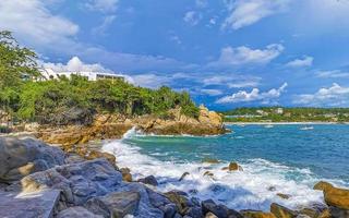 schöne surferwellen felsen klippen am strand puerto escondido mexiko. foto