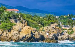 schöne surferwellen felsen klippen am strand puerto escondido mexiko. foto