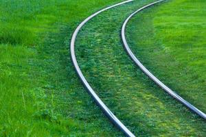 Straßenbahnschienen mit grünem Gras bedeckt foto