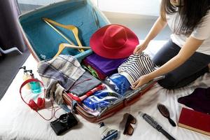Mädchen packt Gepäck und bereitet sich auf ihre Reise vor foto