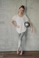 glückliche Frau mit kleinem Pilates-Ball, der nach dem Training im Studio ruht foto