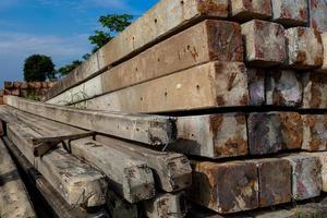 Haufen von Strommasten auf dem Boden. neue Betonmasten auf der Seite der Autobahn in Seitenansicht zum Austausch mit alten und degradierten Masten foto