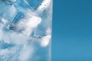 Eiswürfel in einem beschlagenen Glas mit Tropfen Eiswasser Nahaufnahme Makro. weicher selektiver Fokus foto