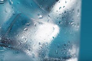 Eiswürfel in einem beschlagenen Glas mit Tropfen Eiswasser Nahaufnahme Makro. weicher selektiver Fokus foto