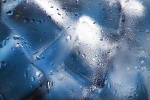 Eiswürfel in einem beschlagenen Glas mit Tropfen Eiswasser Nahaufnahme Makro. weicher selektiver Fokus foto