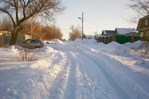 Russisches Dorf im Winter, nicht von Schnee geräumte Straße. foto