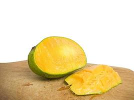 mango halbiert auf holz gelegt. so dass die Innenseite in Orange sichtbar ist. Isoliert auf weißem Hintergrund foto