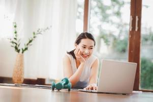 Frau mit Hanteln auf Laptop foto