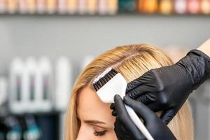 Friseur färbt weibliche Kundenhaare foto