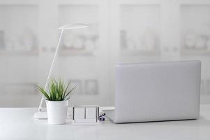 Workstation mit Laptop und Lampe auf dem Schreibtisch foto