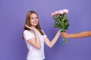 porträt fröhliche junge dame mit romantischem frühlingsstrauß rosa pfingstrosen foto