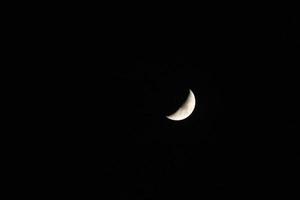 der Mond am dunklen schwarzen Himmel foto