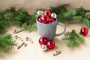 silberne und rote weihnachtsdekorationskugeln im becher mit tannenbaumweihnachtshintergrund foto