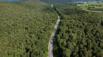 Luftaufnahme einer Autobahn durch einen Wald bei Sonnenuntergang foto