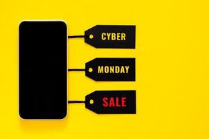 Online-Shopping vom Smartphone mit schwarzen Preisschildern und Wörtern. Cyber-Monday-Konzept.