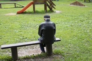 alter Mann, der auf einer Bank sitzt. ältere Person im Park. Rentner ruht in der Natur. foto