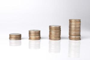 Stapelmünzen mit weißem Hintergrund. konzept des sparens von geld, wirtschaft, investitionen, wachsendem geschäft und reichtum. foto