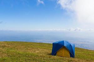 Zelt auf einer Wiese unter blauem Himmel foto