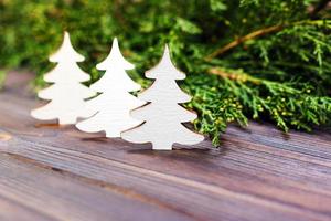 kleiner dekorativer weißer weihnachtsbaum aus holz. neujahrskonzept, geschenk aus kraftpapier foto