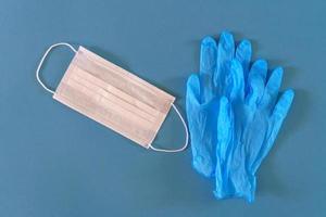medizinische maske und handschuhe auf blauem hintergrund foto