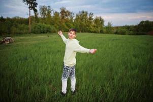 Junge hat Spaß auf der Wiese. Teenager stehen im grünen Gras. foto