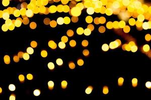 goldener abstrakter Bokeh-Hintergrund. Defokussiert und verschwommen viele runde gelbe Lichter auf dunklem Hintergrund foto