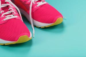 rosa sportschuhe zum laufen auf blauem hintergrund mit freiem platz. foto
