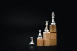 holzwürfel und schach, geschäfts- und marketingstrategiekonzept bei der planung von zielen auf schwarzem hintergrund. foto