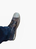 die Füße eines Mannes, der schlammverschmutzte Schuhe trägt foto