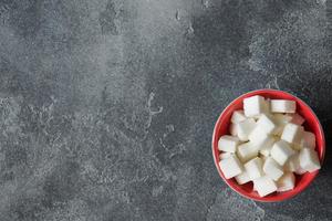 Weiße Zuckerwürfel in einer Platte auf einem dunklen, brutalen Hintergrund, selektiver Fokus foto