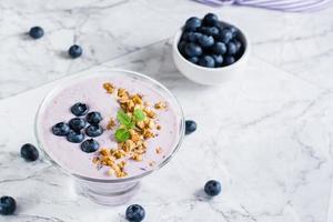 Smoothie-Schüssel mit Heidelbeeren und Müsli auf dem Tisch. Bio-Antioxidans-Diät-Lebensmittel. foto