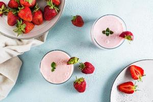 Milch-Smoothie mit Erdbeeren und Minze in Gläsern auf dem Tisch. Gesundes hausgemachtes Essen. Ansicht von oben foto