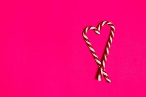 Weihnachtssüßigkeitsherz auf rosa Hintergrund. Platz kopieren foto