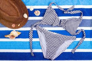 Badeanzug mit Strandzubehör auf blauem Hintergrund foto