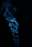 eine vertikale Aufnahme von blauem Tabakrauch auf schwarzem Hintergrund foto