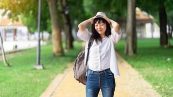 Lifestyle-Bild einer sorglos reisenden lächelnden Frau in weißem Hemd und Hut, die ihre Freizeit im Park verbringt. Sommerstimmung. foto