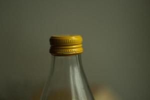 Gelber Deckel auf einer Glasflasche. Wasserflasche aus Glas. foto