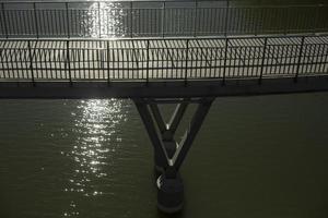 moderne Brücke über Wasser. Brückenstützen. Details des Stadtparks. Geländer auf Brücke. foto
