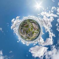 winziger Planet im Himmel mit Wolken, die die Altstadt, die Stadtentwicklung, historische Gebäude und Kreuzungen überblicken. Umwandlung eines sphärischen 360°-Panoramas in eine abstrakte Luftaufnahme. foto