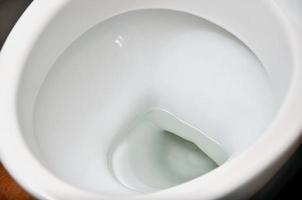 ein Foto einer Toilettenschüssel aus weißer Keramik in der Umkleidekabine oder im Badezimmer. Sanitärkeramik zur Bedarfskorrektur