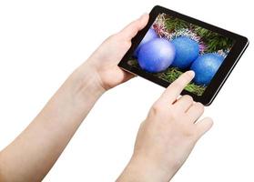 Hand berührt Tablet-PC mit Weihnachtsschmuck foto