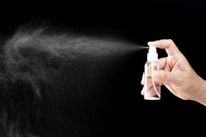 dunkles fotokonzept der hand ein mann drückt die alkoholsprühflasche zur schutzreinigung und reinigung des pandemievirus unter quarantäne foto
