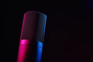 studiomikrofon auf dunklem hintergrund mit neonlichtern foto