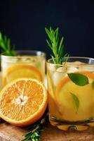 Orange frische Limonade im Glas auf dunklem Hintergrund foto