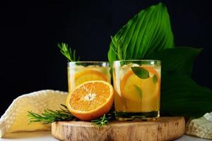 Orange frische Limonade im Glas auf dunklem Hintergrund foto