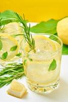 Getränk mit Zitrone und Rosmarin auf dem Tisch foto