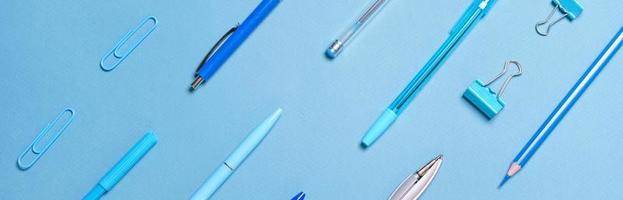Kugelschreiber Bleistifte Zirkel Büroklammern, die in blauen Linien und mit Hintergrund angeordnet sind foto
