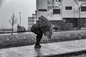 mit einem Regenschirm im Schnee spazieren gehen foto