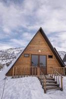 eine vertikale Aufnahme eines von Schnee umgebenen Holzhauses. ein Erholungsgebiet in den Bergen foto